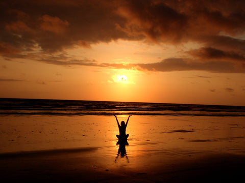 A person meditating at the seashore