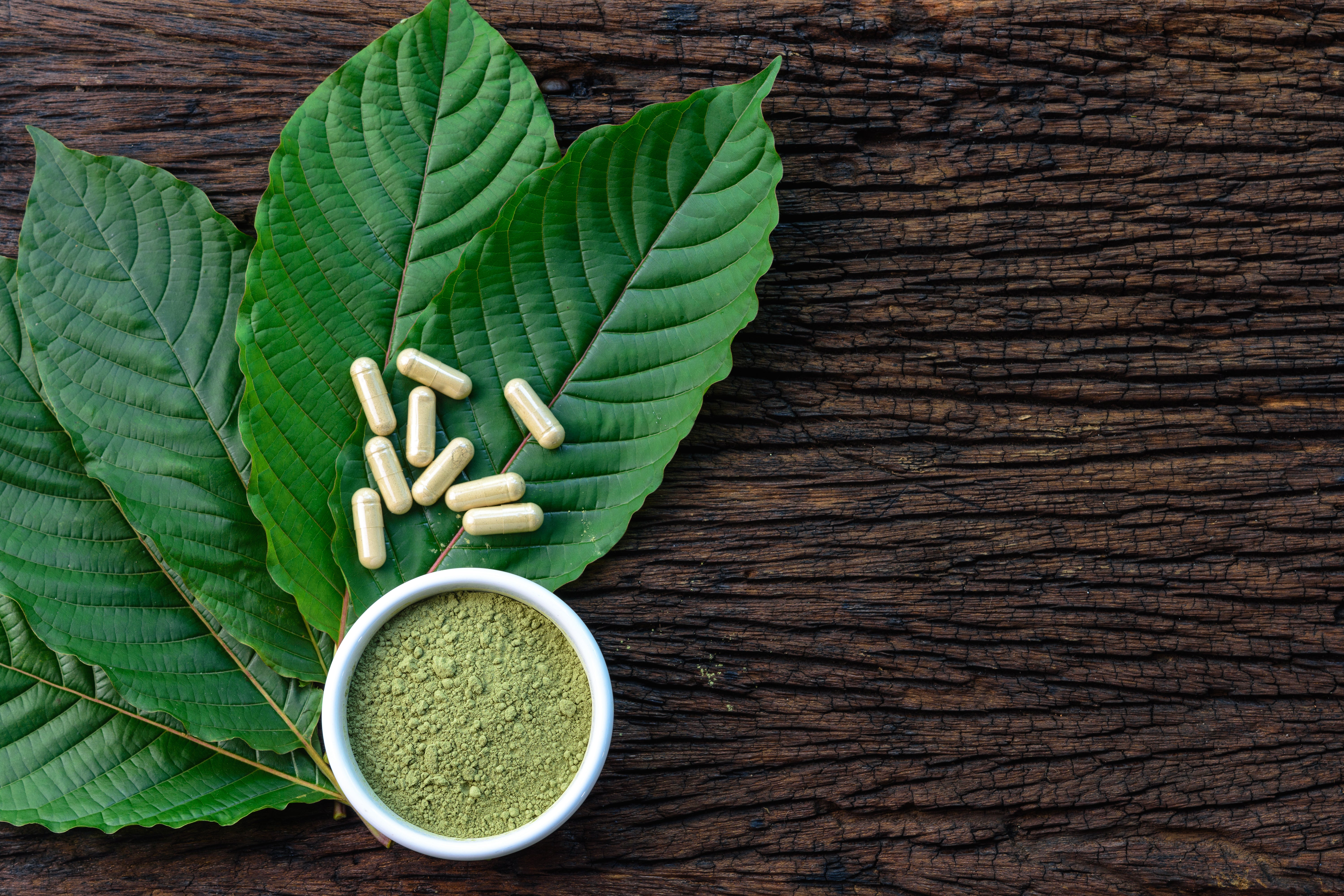 Kratom leaves and products on a wooden table